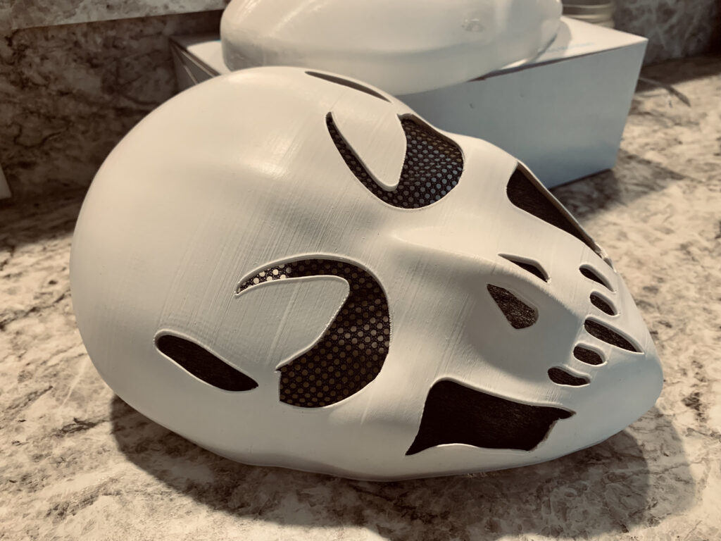 I had the privilege of working on my first custom build as a gift for someone’s husband back Fall of 2023. She asked me to physically create a mask based on this AI generated image she created. It was a great project that involved lots of surface modeling and therefore lots of fine tuning! White 3D printed. final version